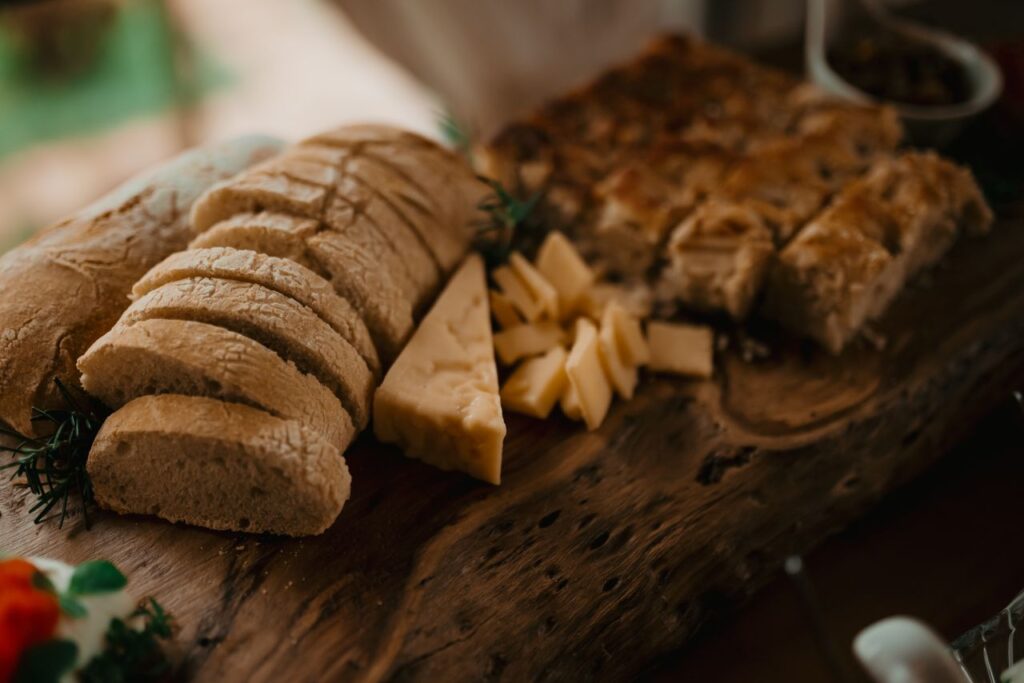 Artistic display of sliced bread and cheese on a rustic wooden board for gourmet dining.